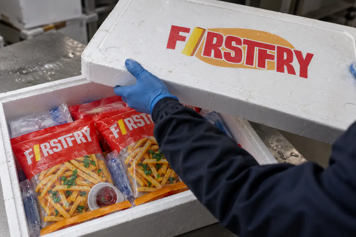 Gloved hands closing an insulated sample box of FirstFry packs and ice packs