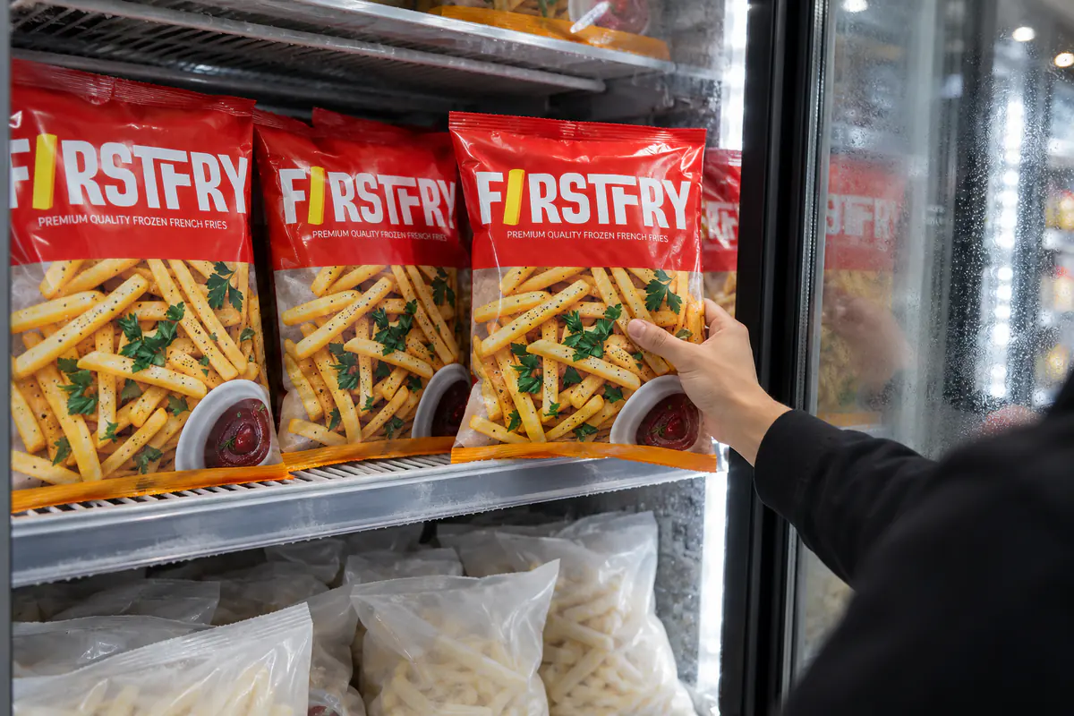 A freezer with FirstFry packs on the upper shelves and plain white bags below